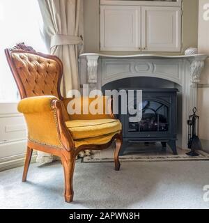 Fauteuil marron placé à côté d'une cheminée dans une chambre Banque D'Images