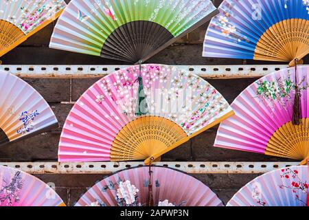 Gros plan de plusieurs ventilateurs de main de plusieurs couleurs mis les uns à côté des autres Banque D'Images