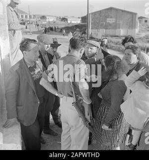 Israël 1948-1949 Nouvelles arrivées (pétrole) dans le camp de transit St. Lucas à Haïfa en conversation avec un superviseur armé dans les résidences Date: 1948 lieu: Haïfa, Israël mots clés: Casernes, surveillance, émigrants, camps, armes à feu Nom de l'institution: Saint Luke Banque D'Images
