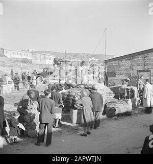 Israël 1948-1949 Nouvelles arrivées (pétrole) dans le camp de transit St. Lucas à Haifa lors du ramassage de leurs bagages dans les chambres d'hébergement avec dans les casernes de fond Date: 1948 lieu: Haïfa, Israël mots clés: Bagages, casernes, émigrants, camps Nom de l'institution: Saint Lucas Banque D'Images