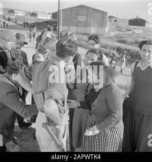 Israël 1948-1949 Nouvelles arrivées (pétrole) dans le camp de transit St. Lucas près de Haïfa en conversation avec un superviseur armé aux quartiers avec des casernes en pierre en arrière-plan Date: 1948 lieu: Haïfa, Israël mots clés: Casernes, surveillance, émigrants, camps, armes à feu Nom de l'institution: Saint Luke Banque D'Images