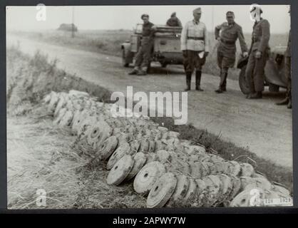 Nettoyage des mines terrestres près de Hoek van Holland. Les mines collectées attendent le transport vers l'endroit où elles seront rendues inoffensives. En arrière-plan soldats allemands qui sont déployés à la fin Date: Août 1945 lieu: Hoek van Holland mots clés: Mines terrestres, seconde Guerre mondiale, reconstruction Banque D'Images