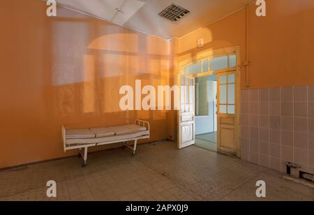 Silhouettes et ombres de la fenêtre sur le mur de la chambre avec un lit d'hôpital dans un hôpital abandonné, la nuit Banque D'Images