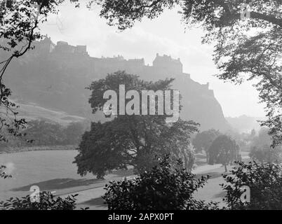 Ecosse - Cityscape Edinburgh Park avec derrière lui la silhouette du château d'Edingburgh Annotation: Edinburgh Castle est un château du XVIIe siècle, situé sur Castle Rock, un bouchon volcanique Date: 1934 lieu: Edinburgh, Grande-Bretagne, Ecosse mots clés: Panoramas Banque D'Images