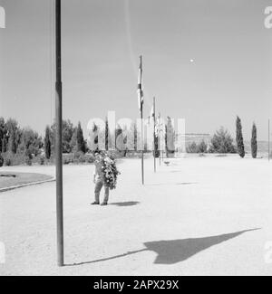 Israël 1964-1965: Jérusalem (Jérusalem), plantation Herzberg avec une rangée d'arbres cyprès, une rangée de drapeaux d'Israël et un jeune homme tenant une couronne de fleurs dans le cimetière d'annotation: Herzberg, également appelé Mont du Souvenir, est le cimetière national d'Israël, sur le côté ouest de Jérusalem. La montagne porte le nom de Theodor Herzl, fondateur du sionisme politique moderne. La tombe d'Herzl est située au sommet de la colline Date: 1964 lieu: Herzberg, Israël, Jérusalem mots clés: Couronnes, brouettes, conifères, parcs nationaux, ombres, drapeaux Banque D'Images