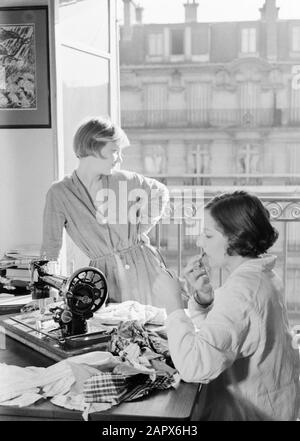 Midinettes [Hans en Renée] Renée (à gauche) et Hans derrière une machine à coudre. Hans stylos ses lèvres Annotation: Hans et Renée sont les stepfilles de Van de Poll Date: 1937 lieu: France, Paris mots clés: Cosmétiques, maquillage, machines à coudre, femmes Nom personnel: Hans, Renée Banque D'Images