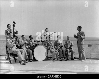 Voyage en mer avec Mme Johan van Oldenbarnevelt en Norvège Ship Orchestra joue sur le pont Date: 1933 lieu: Norvège mots clés: Instruments du vent, croisières, bateaux de croisière, chefs d'orchestre, guitares, musicis, instruments de musique, orchestres, navires à passagers, saxophones, instruments à cordes, tourisme, batterie, trompettes, nom de trompettes: Oldenbarnevelt, Johan van Banque D'Images