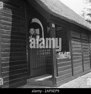 Eduard van Beinum à sa maison de campagne Sepha van Beinum-Janssen, la femme du chef Eduard van Beinum, avec le caniche David dans ses bras, regarde par la porte à moitié ouverte de leur maison de campagne à Garderen Date: 5 juin 1954 lieu: Garderen, Gelderland mots clés: Portes, chiens, maisons de campagne, femmes Nom personnel: Beinum-Janssen, Sepha Van Banque D'Images