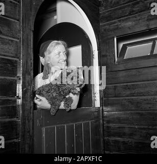 Eduard van Beinum à sa maison de campagne Sepha van Beinum-Janssen, la femme du chef Eduard van Beinum, avec le caniche David dans ses bras, regarde par la porte à moitié ouverte de leur maison de campagne à Garderen Date: 5 juin 1954 lieu: Garderen, Gelderland mots clés: Portes, chefs d'orchestre, maisons de pays, femmes Nom personnel: Beinum-Janssen, Sepha Van Banque D'Images