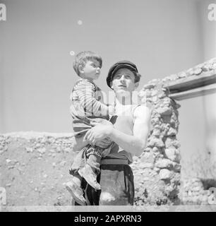 Israël 1948-1949 Père avec enfant sur bras à l'endroit où la famille construisent leur maison. Cet émigrant porte sur l'avant-bras le numéro de camp du camp de concentration Auschwitz Date: 1948 lieu: Israël mots clés: Camps de concentration, émigrants, enfants Banque D'Images