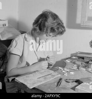 Israël - Eilat Woman travaillant sur la pierre d'Eilat dans des bijoux dans une entreprise où cette pierre est traitée et transformée. Date : 1 janvier 1963 lieu : Eilat, Israël mots clés : travailleurs, pierres précieuses, outils, pierres semi-précieuses, industrie, machines, anneaux Banque D'Images