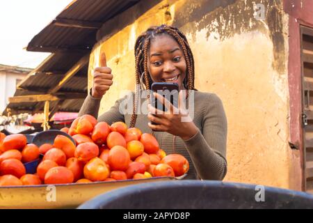 jeune femme noire utilisant son smartphone sur le marché Banque D'Images