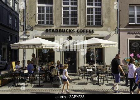 Gdansk, POLOGNE - 05 août 2019 : terrasse Starbucks café avec parasol gris au centre de Gdansk. Les gens boivent du café et du capuccino dans la rue. Banque D'Images