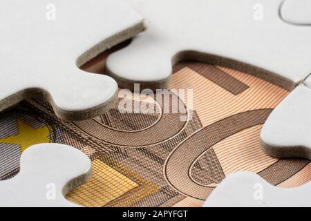 Gros plan d'une partie de l'argent vue sous un pièce d'un puzzle retirée Banque D'Images