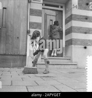 Heitje voor een chore Annotation: Young Boy Scout balaie le trottoir Date: 1 avril 1959 mots clés: Boy Scout Banque D'Images