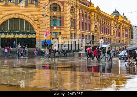 Melbourne, Australie - 21 avril 2017 : piétons traversant la route devant la gare de Flinders Street le jour des pluies Banque D'Images