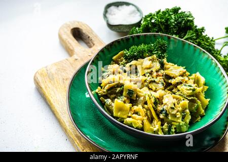 D'été traditionnelle géorgienne lobio plat d'haricots verts avec des oeufs et des herbes sur fond de pierre with copy space Banque D'Images