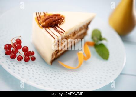 Morceau de gâteau de carottes avec crème de lait, carottes et noix isolées, closure Banque D'Images