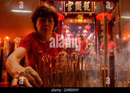 Makassar, Indonésie. 24 janvier 2020. Une femme brûle de l'encens pendant la célébration au temple Xian Ma à Makassar.Des Centaines de bougies sont allumées à minuit et Des Prières pour le nouvel an lunaire chinois comme expression de gratitude pour toute la fortune et pour l'espoir d'une meilleure vie dans l'année du rat. Crédit: Sopa Images Limited/Alay Live News Banque D'Images