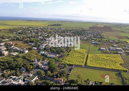 Village de peuplement encerclé dans de vastes champs de canne à sucre, Maurice. Banque D'Images