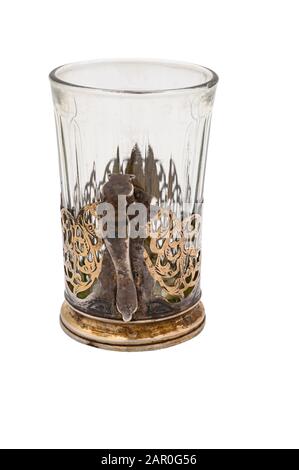 Verre à facettes dans un ancien porte-gobelet en métal blanc vintage. Gros plan. Isoler sur un fond blanc Banque D'Images