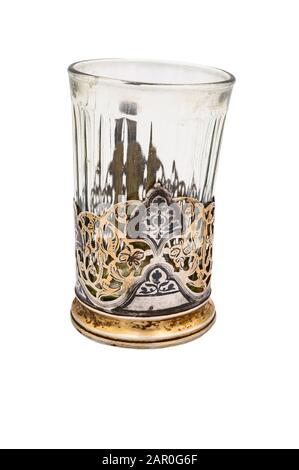 Verre à facettes dans un ancien porte-gobelet en métal blanc vintage. Gros plan. Isoler sur un fond blanc Banque D'Images