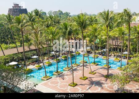 Piscine extérieure entourée de palmiers, à l'Chatrium Hotel Royal Lake Yangon, Myanmar (Birmanie), l'Asie en février Banque D'Images