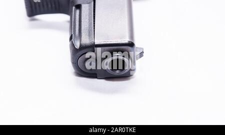 Le museau d'un pistolet noir semi-automatique de 9 mm avec un fond blanc Banque D'Images