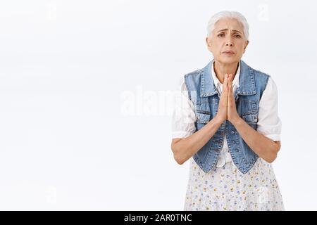 La vieille dame vous supplie pour vous aider, a besoin d'aide pour vous asap. La grand-mère moderne lui demandant de l'écouter, supplantant, plaider pour des excuses, frognant un appareil photo d'apparence déaisée Banque D'Images