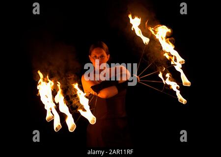 femme exécutant le feu tenant des ventilateurs de feu éclairés Banque D'Images