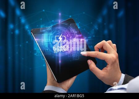 Businessman holding a smartphone pliable avec l'industrie 4.0 Inscription, nouvelle technologie SUPPORT TECHNIQUE concept