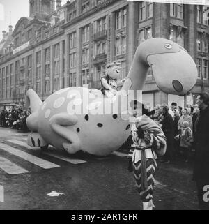 Entrée de Saint Nicolas à Amsterdam Zwarte Piet pose devant une circonscription Dino avec sur son dos Barney Rubble de la série de dessins animés The Flintstones Annotation: Dans le magasin de fond de Bijenkorf Date: 20 novembre 1965 lieu: Amsterdam, Noord-Holland mots clés: Sinterklaas, Zwarte Piet, public, traditions, culture populaire Banque D'Images