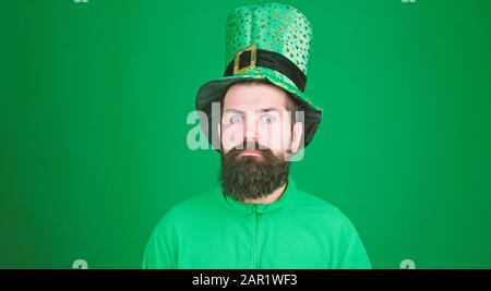 Choqué et heureux. Bonne journée de patrins de saint. Homme barbu à grands yeux ouverts célébrant la Saint patricks jour. Hipster dans un chapeau et un costume de lepreun. Homme irlandais avec barbe portant le vert. Banque D'Images