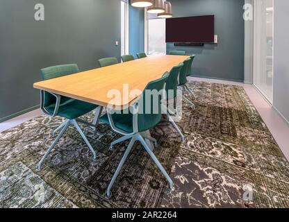 Chaises mises à côté d'une table dans une chambre avec une moquette à motifs Banque D'Images