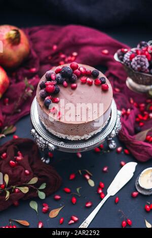 Cliché vertical d'un gâteau au chocolat avec baies fraîches et graines de grenade dessus Banque D'Images