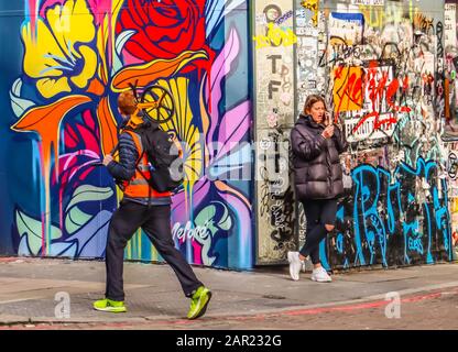 Grafitti dans la rue avec passants Banque D'Images