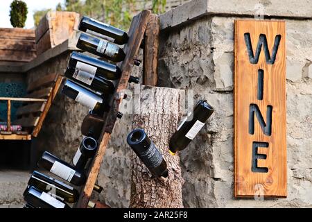 Tbilissi, GÉORGIE - 24 septembre 2019 : une collection de bouteilles de vin géorgiennes vides sur un rack en bois. Image du concept de dégustation de vins. Banque D'Images
