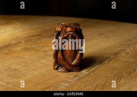 Figurine singe bancale en bois sur fond en bois. Je ne vois pas. Trois Monkeys Sages - Figurine de chims représentant "ne rien méchant" posture. Banque D'Images