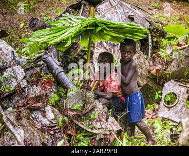 Deux garçons avec parapluies auto-fabriqués dans la jungle de Bougainville, Papouasie-Nouvelle-Guinée Banque D'Images