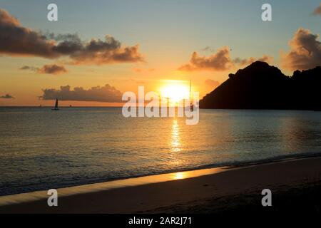 Un magnifique coucher de soleil où - les rayons du soleil, l'eau tranquille et le ciel lumineux au crépuscule Banque D'Images