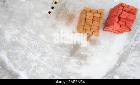 Concept de construction, deux palettes sur une surface en béton blanc, bannière avec place pour le texte. Vue de dessus. Matériaux de construction de différentes couleurs. Banque D'Images