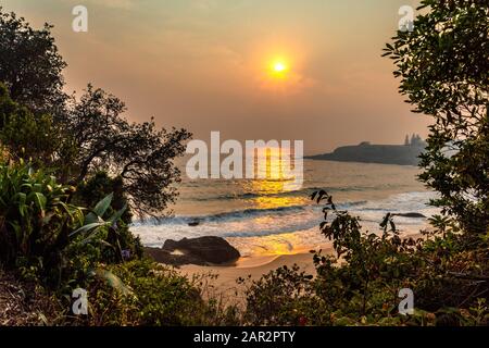 Lever de soleil fumé sur la plage de Kendalls à Kiama, Nouvelle-Galles du Sud, pendant la saison de feux de brousse de décembre 2019 Banque D'Images