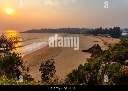 Lever de soleil fumé sur la plage de Kendalls à Kiama, Nouvelle-Galles du Sud, pendant la saison de feux de brousse de décembre 2019 Banque D'Images