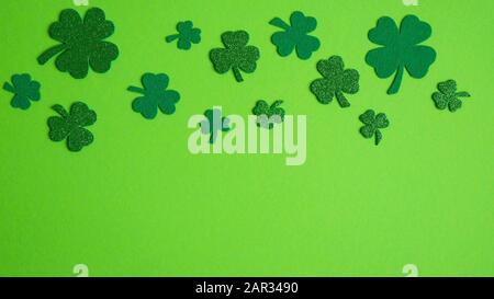 Bordure du cadre de shamrock et quatre trèfle de feuilles sur fond vert. Concept « Happy St Patrick's Day ». Banque D'Images