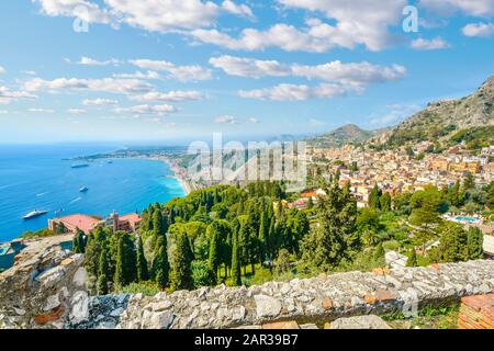 Regardant vers le bas de l'ancien théâtre grec de Taormina, en Italie, sur l'île italienne de Sicile, avec des bateaux et des resorts parsemant la mer Méditerranée Banque D'Images