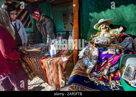 La Paz, Bolivie. 22 janvier 2020. Une fille et son parent obtiennent naïpes future lecture par une sorcière andine locale qui a la statue d'Ekekeo à sa place. Ekeke représente la fertilité et la prospérité à la Paz Bolivie Alasitas fête de la prospérité . Là, les gens achètent ce qu'ils veulent avoir pendant l'année ou par elle pour d'autres personnes, comme dans un "marché de souhaits". Tout est généralement basé sur les mniatures des choses que les gens veulent. Le plus comon est d'acheter de faux argent, comme des Dolards américains, des pesos Bolivianos ou même des euros. Crédit: Christian Lombardi/Zuma Wire/Alay Live News Banque D'Images