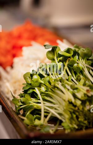 Les carottes julienne, les champignons énokitake et les choux de radis verts coupés et utilisés pour faire des sushis Banque D'Images