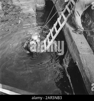 Récupération: Amsterdam Sous la direction du capitaine J. Breman, la 2ème Compagnie Genie d'Amsterdam a commencé avec des réparations de très grande portée. Il a pour tâche de supprimer dès que possible tous les obstacles à la circulation dans la ville d'Amsterdam, y compris les travaux de compensation dans le port. Le travail consiste également à nettoyer les barrières faites par les Allemands dans les rues, en fermant les bâches dans le pavé causé par des blocs de bois: Pompage des caves inondées, etc. Une tâche très spéciale est d'éclairer les grues de levage à la Javakade, qui sont créées par les Allemands ont été soufflées et profondément dans l'eau c Banque D'Images