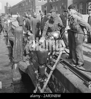 Récupération: Amsterdam Sous la direction du capitaine J. Breman, la 2ème Compagnie Genie d'Amsterdam a commencé avec des réparations de très grande portée. Il a pour tâche de supprimer dès que possible tous les obstacles à la circulation dans la ville d'Amsterdam, y compris les travaux de compensation dans le port. Le travail consiste également à nettoyer les barrières faites par les Allemands dans les rues, en fermant les bâches dans le pavé causé par des blocs de bois: Pompage des caves inondées, etc. Une tâche très spéciale est d'éclairer les grues de levage à la Javakade, qui sont créées par les Allemands ont été soufflées et profondément dans l'eau c Banque D'Images