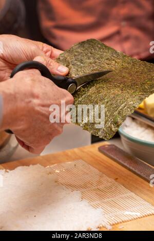 Démonstration du rouleau à sushi sur la façon de placer des ingrédients pour un rouleau à sushi extérieur, avec du riz et des algues Banque D'Images